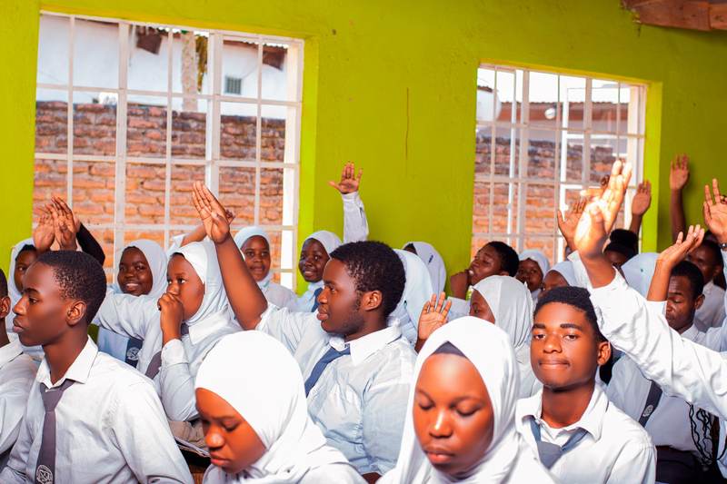 Students raising their hands to answer a question in class