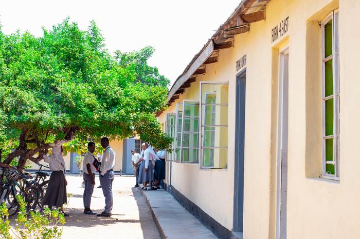 Students gathered outside a classroom block with bicycles